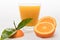 Orange juice in glass with pieces of oranges and green leafs on black background. Summer and freshness concept