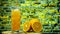 Orange juice in a glass with a straw in a transparent glass against the background of a yellow brick wall. Yellow lemonade