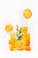 Orange juice in glasses and jug with slices and green leaves at white background. Healthy drinks. Summer beverages. Refreshing.