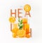 Orange juice in glasses and pitcher with fresh orange fruits slices, leaves and ice cubes with word health at white background.