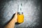 Orange juice in the jar with straw holding in hand on the gray and white background