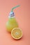 Orange juice in light bulb glass on bright peach background