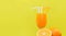 Orange juice summer glass with piece orange fruit with yellow background