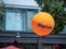 Orange Kaiser Permanente thrive balloon flying in an urban area