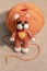 Orange knitted kitten toy with a ball of thread, home needlework