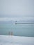 Orange ladder into ocean on beach in winter