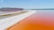 Orange lake in Crimea. Shot. Top view of bright orange lake water against white sand. Extraterrestrial landscape of