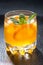 Orange lemonade with ice in a glass, vertical