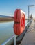 Orange life buoy equipment on a long steel jetty