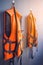 Orange life jackets hanged on plain grey wall by swimming pool for emergency