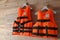 Orange life jackets on wooden background. Personal flotation device