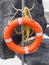 Orange lifebelt or life preserver with yellow rope attached
