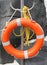 Orange lifebelt with yellow rope