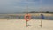 Orange lifebuoy and blue vest on a white sandy beach on the background of the ocean coast