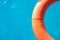 Orange lifebuoy floating on a pool