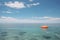 Orange lifebuoy floating in vast open ocean with endless blue water and copy space