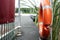 Orange lifebuoy hang on the pier, on the lake, on a summer day. Concept of a safe holiday.