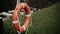 An orange lifebuoy hanging from  river