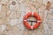 Orange lifebuoy hanging on a wall sandstone