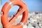 Orange lifebuoy for people near rocks at the sea