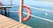 Orange lifebuoy on pier and pier against the backdrop of sea