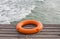 The orange lifebuoy put on the port near the sea