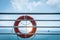 Orange lifebuoy ring hanging on ferry boat with ocean background