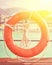 Orange lifebuoy with rope on a wooden pier near sea.