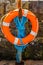Orange lifebuoy on a stone wall rescue, blue rope, ocean shore