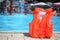 Orange lifejacket near pool in aquapark