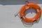 Orange lifesaver ring hanging on boat