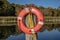 Orange Lifesaver Strapped to Wooden Post