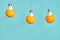 Orange in a light bulb is suspended from a rope. turquoise background. creative concept