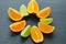 Orange and lime sliced segments on black slate stone. Vitamin concept