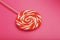 Orange Lollipop on a pink background with a soft contrast. Minimal concept with copy space