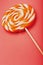 Orange Lollipop on a pink background with a soft contrast. Minimal concept with copy space