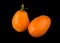 Orange long tomatoes on a black background