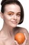 Orange make-up on a nice photo model holding an orange in her hand / offer