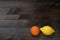 Orange mandarin and yellow lemon on a dark rustic wooden background
