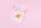 Orange menstrual cup on cotton bag on pink background.