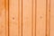 Orange metal fence with vertical corrugated stripes