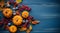 Orange mini pumpkins, red berries, and wedge leaves arranged on a rustic blue wooden backdropwith copyspace. Autumn composition.