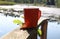 Orange mug with hot tea on the railing of the forest lake bridge, close-up-the concept of wonderful nature walks in the autumn