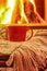 Orange mug for tea or coffee, wool things near cozy fireplace, w