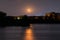 Orange mystic vivid moon on night sky on lake