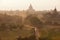 Orange mystical sunrise landscape view with silhouettes of old ancient temples and palm trees in dawn fog from balloon