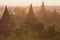 Orange mystical sunrise landscape view with silhouettes of old ancient temples and palm trees in dawn fog from balloon