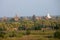 Orange mystical sunrise landscape view with silhouettes of old ancient temples and palm trees in dawn fog from balloon