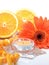 Orange objects on a white background: an orange gerbera flower, an amber beads and candle - still life