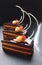 Orange Opera cake slices with citrus ganache and white chocolate decorations